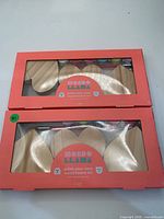 Front view of two boxed Mondo Llama paint-your-own wood hearts kits