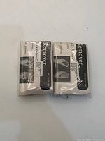 Front view of two packaged lint removers showing printed inserts