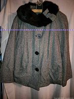 front view of tweed jacket with fur collar and bow
