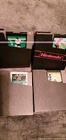 Four NES cartridges partially inserted into black Nintendo sleeves