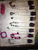 Entire lot laid out showing eight necklace/earring sets and two bracelets