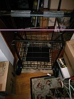 Front view of black folding shopping cart showing basket and wheels