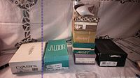 Stack of nine shoeboxes showing brands and sizes