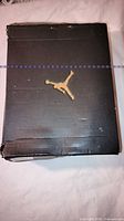 Black Jordan shoe box with gold Jumpman logo showing crushed edges