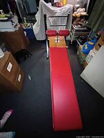 Full view of red padded AB board bench