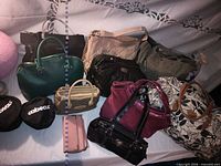 Wide view of assorted handbags and bags arranged on table