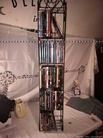 Full view of black metal DVD tower loaded with discs