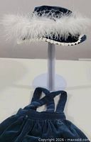 Velvet hat on stand and top of matching dress visible