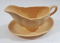 Side view of Grindley Laburnum Petal Ware gravy boat on attached underplate