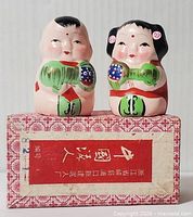 Front view of both figurines on box