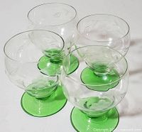 Four etched crystal goblets with green bases top view