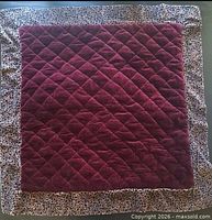 Full view of front of cushion cover showing maroon quilted center and leopard print border
