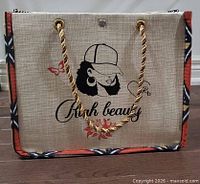 Front view showing Riah Beauty graphic, chain handles, patterned trim