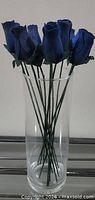 Dozen navy wooden roses upright in clear glass vase