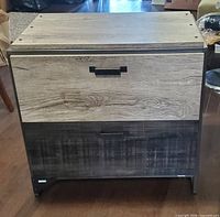 Front view showing assembled cabinet with two drawers and wood-grain laminate finish