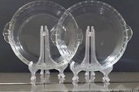 Two clear glass pie dishes on stands