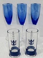 Front view of three cobalt blue flutes and two shooter glasses with anchor motif