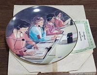 Front of collector plate showing operator artwork, COA and packaging partially visible