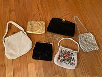 Overview of all six handbags arranged on wooden floor