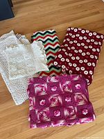 All five folded textile pieces displayed on floor