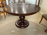 Full view of round cherry pedestal dining table