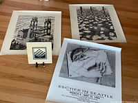 Overview of three posters and ceramic tile on table