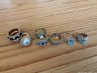 All seven rings lined up on wood background