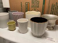 All eight vases grouped, showing sizes, colors, materials