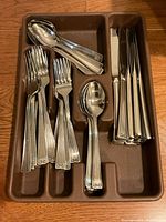 Complete flatware set arranged in brown plastic tray