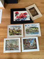 Group shot of all artwork: framed watercolor, woodblock on mat, four unframed prints