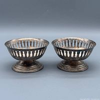 Front view of both matching silver-plated pierced pedestal bowls