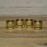 Four brass napkin rings front view