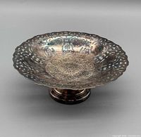 Top view showing pierced rim, engraved center, tarnish