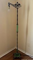 Full view of Victorian bronze-colored floor lamp in corner showing overall structure