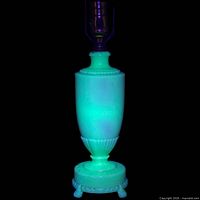 Lamp glowing green under UV light showing uranium content