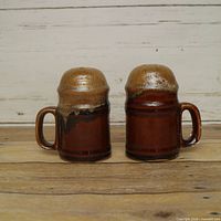 Front view of both shakers showing handles and drip glaze tops