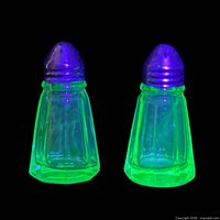 Pair of shakers glowing under black light