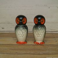 Front view of both ceramic owl shakers showing colors and design