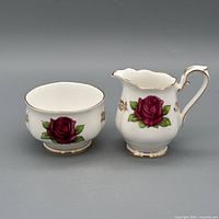 Creamer and sugar bowl front view showing rose motif and gold trim
