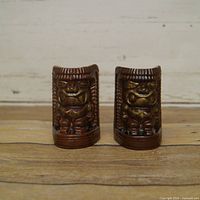 Front view of both tiki shakers showing glaze color and facial detail