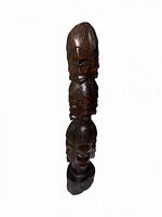 Full view of carved wooden totem showing three stacked faces