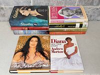 Group shot of all nine hardcover books arranged in two stacks showing covers and spines