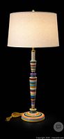 Full view of multicolour striped table lamp base with staging shade
