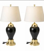 Front view of both black and brass lamps with cords visible, no shades included