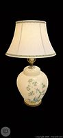 Full view of the ivory ceramic lamp with shade (shade not included) showing painted branch and bird design