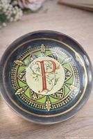 Top view of clear glass paperweight displaying monogram design