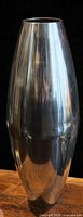 front view of tall polished aluminum vase