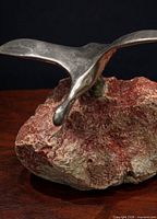 Front left view of aluminum Canada goose on red/cream rock base