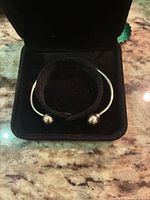 Bracelet in velvet box, front view showing ball end caps