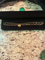 Necklace laid in black presentation case showing full chain and heart charm